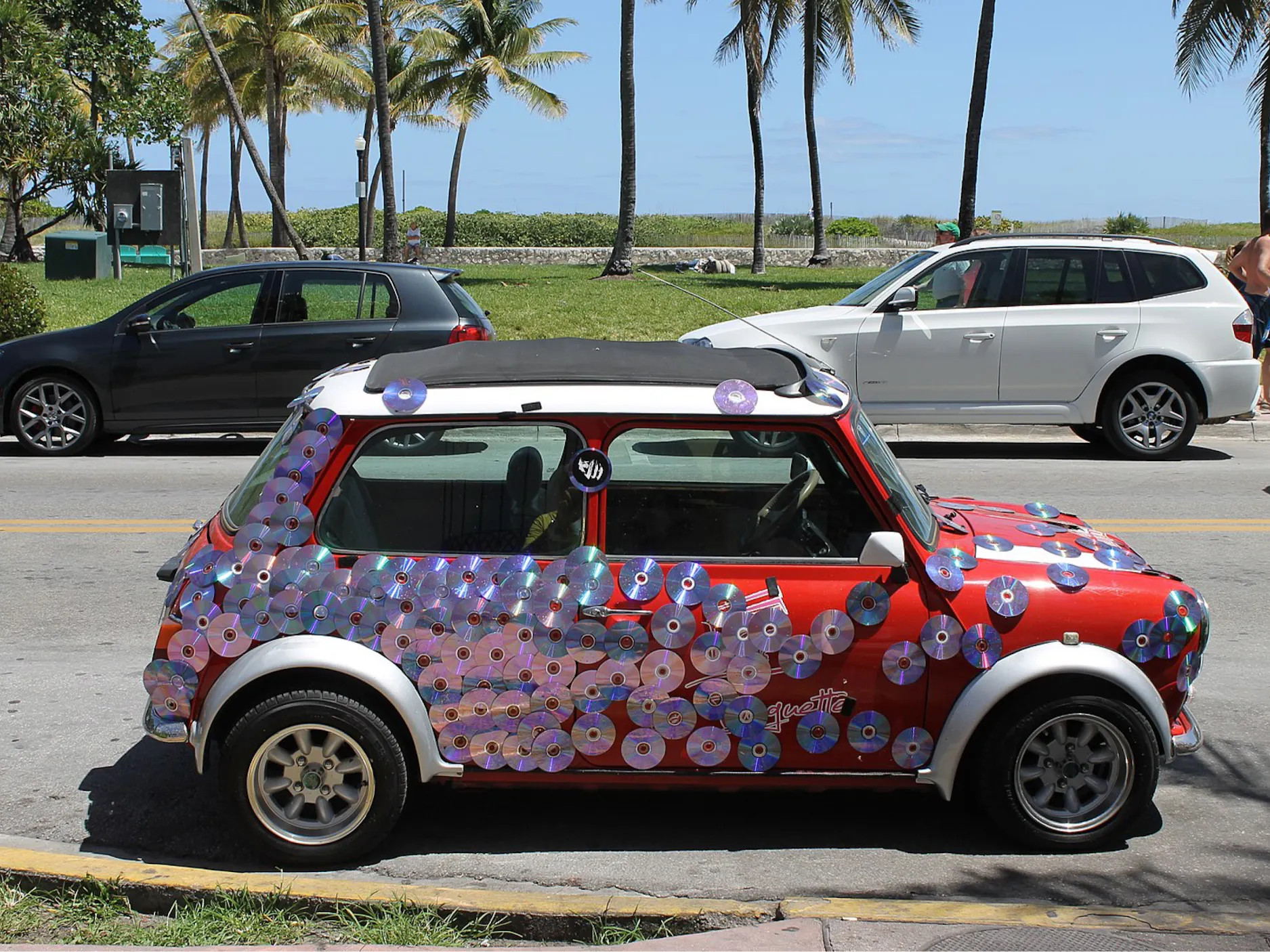 Rdeč Mini Morris avtomobil obljepljen z zgoščenkami.